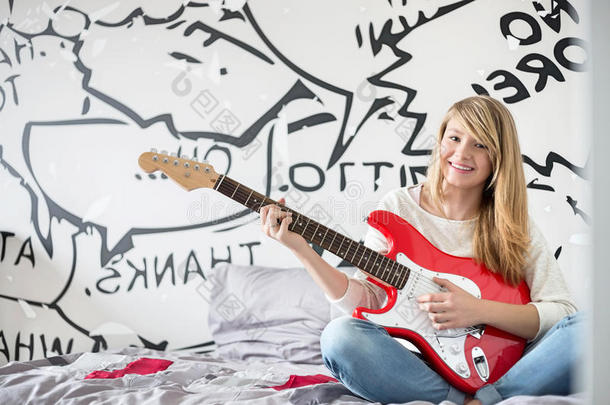 少女在卧室弹吉他的全幅肖像