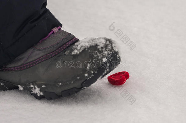 脚在雪中跺着心。 不快乐的爱。