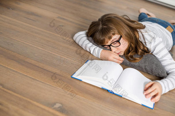 青少年女孩在地板上学习时睡觉的高角度视角