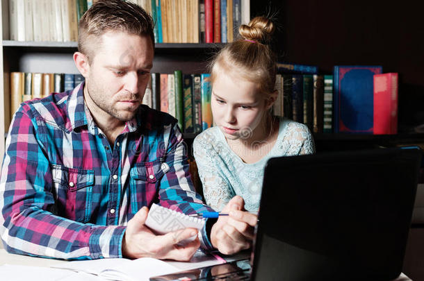爸爸和女儿一起在笔记本电脑上学习。
