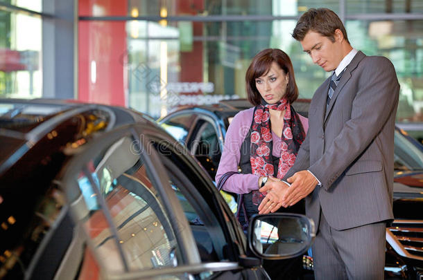 汽车推销员向客户解释汽车的特点