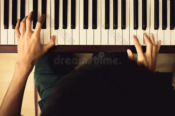 靠近小男孩的手，弹钢琴。 老式色调过滤器