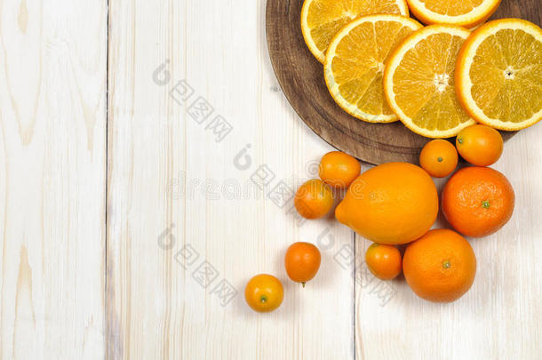 新鲜成熟的柑橘。 木制桌子上的柠檬、金橘和橘子