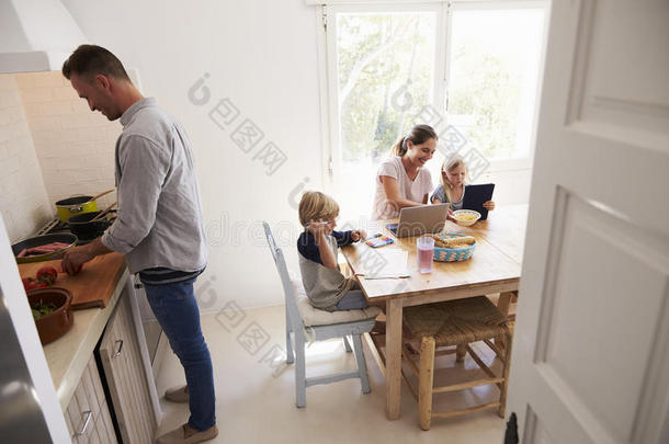 <strong>爸爸做饭</strong>，妈妈和孩子在厨房的桌子上