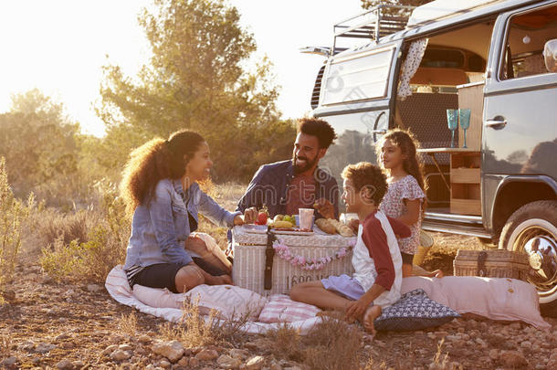 一家人在他们的露营车旁边野餐，全长的