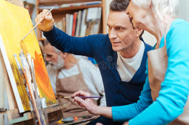 很高兴的艺术家向老妇人展示<strong>如何画</strong>画。