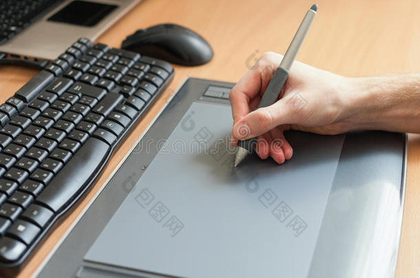 平面设计师使用数字平板电脑和电脑在办公室。