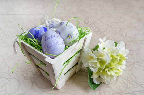 复活节小篮子，上面有彩色鸡蛋和白板上的一朵小花。