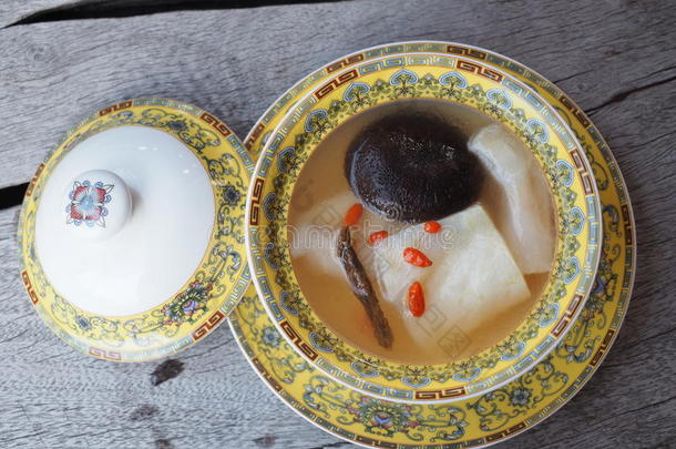 清汤中国风格的新鲜鱼毛与黑色蘑菇和中草药。