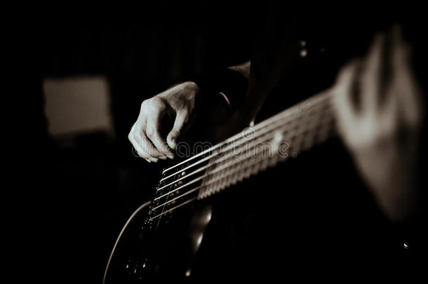 家伙弹吉他，黑色的白色，柔和的焦点，特写