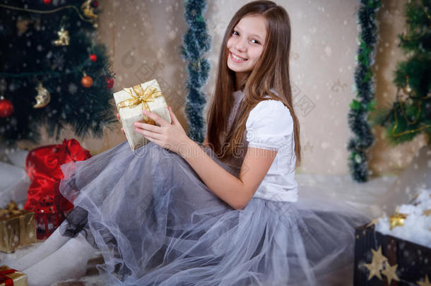 女孩<strong>坐在</strong>圣诞<strong>树下</strong>的礼品盒里