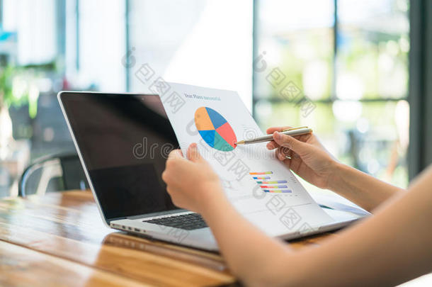 商务人士在开会时使用笔记本电脑和财务图表