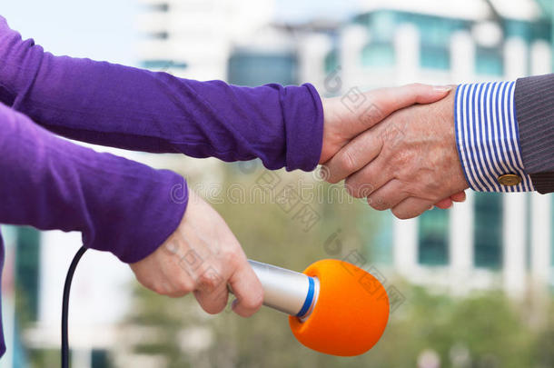 商人和一名<strong>女记者</strong>在媒体采访前握手