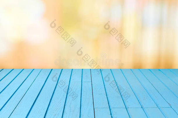 空的木制蓝色桌子，在模糊的温暖的背景上