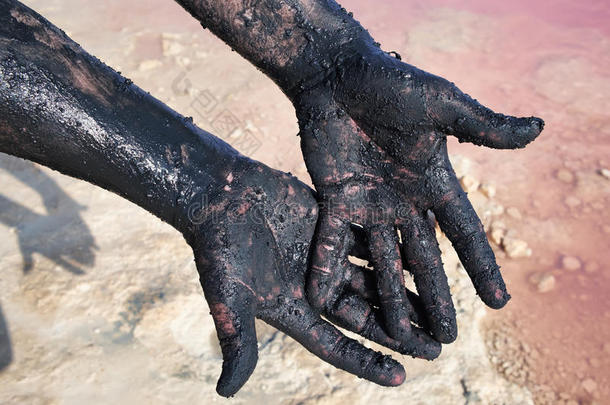 男人的手抹黑泥。 特写镜头。 在拉斯拉纳斯湖，托里维亚。 西班牙。