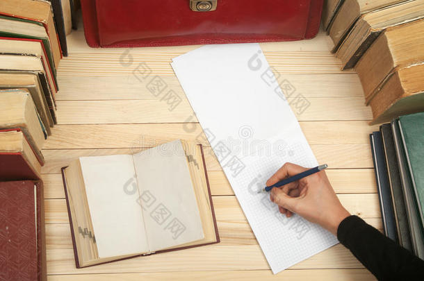 遵守法律。 坐在桌子旁的专业律师签署文件。 在木桌上的书，文件，红色公文包
