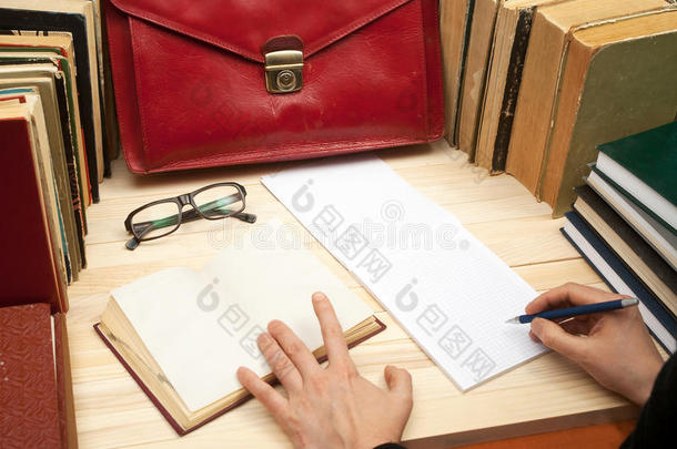 遵<strong>守法</strong>律。 坐在桌子旁的专业律师签署文件。 在木桌上的书，文件，眼镜，红布里