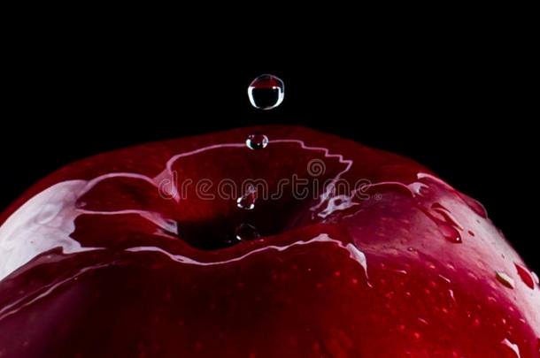 新鲜的红色苹果，水滴在黑色背景反射下降