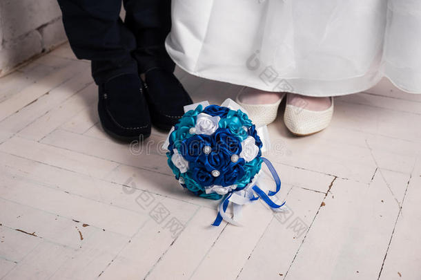 蓝色婚礼花束和结婚戒指在枕头上