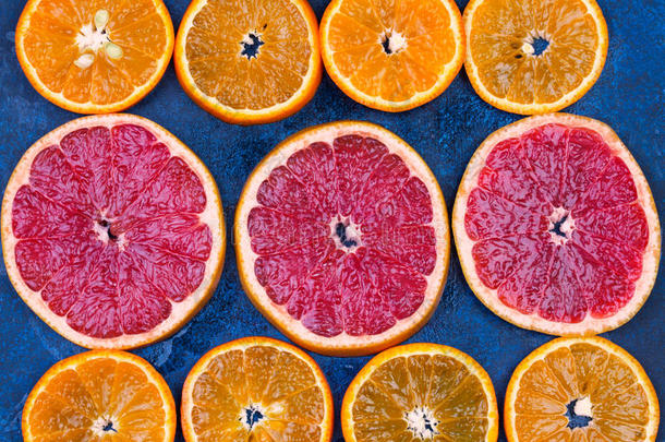 新鲜橙子，葡萄水果和玛德琳片在黑暗的石头背景。
