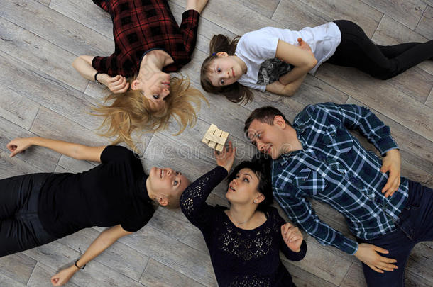 一群不同的朋友，大人和孩子，在地板上玩砖块游戏