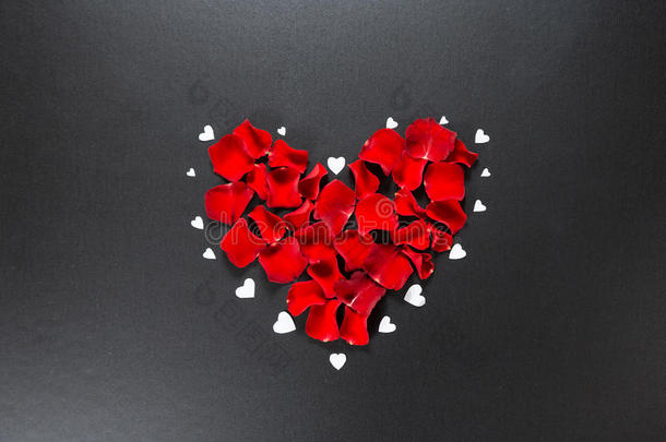 美丽的红色玫瑰花瓣形状的心在黑色的背景。 情人节明信片`3月8日，母亲节
