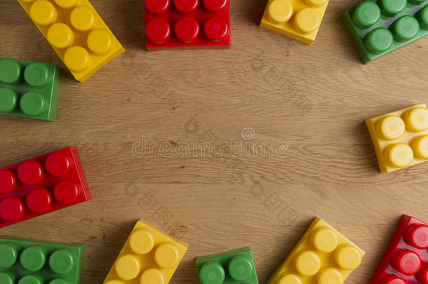 彩色塑料积木在木制背景作为玩具框架板与复制空间的文本。 平躺。 上面