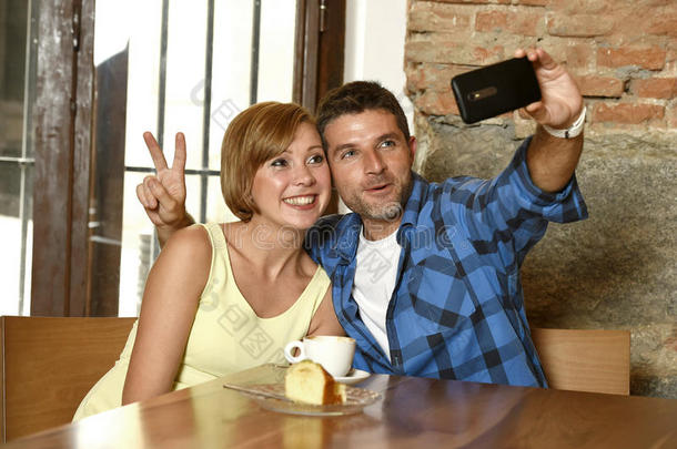 一对<strong>夫妇</strong>在咖啡店用手机拍<strong>自拍照</strong>片，在浪漫的爱情概念中微笑快乐