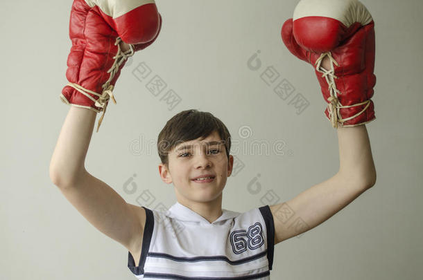 男孩戴着拳击手套，举起双手表示胜利