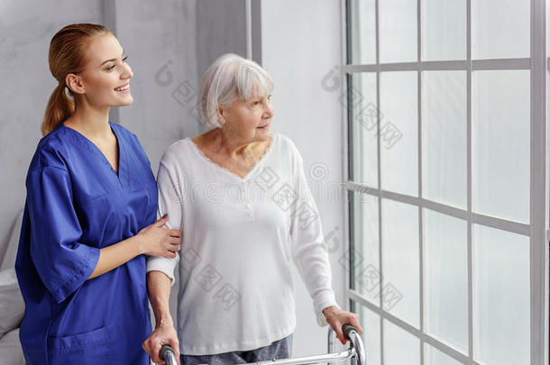 快乐的退休老人在诊所的房间里，在时间桶里散步