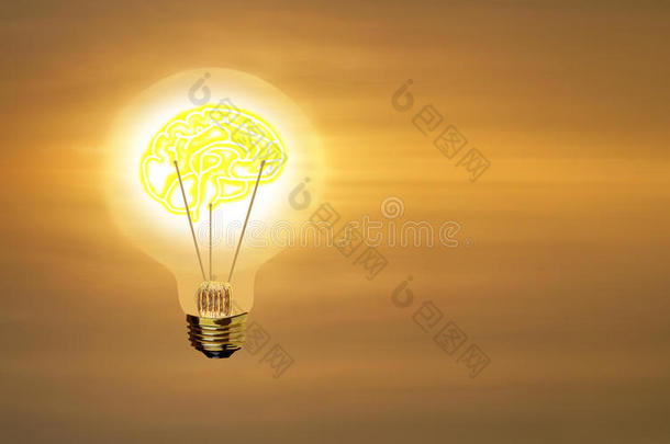 灯泡，金色的大脑在太阳升起的天空上闪闪发光。
