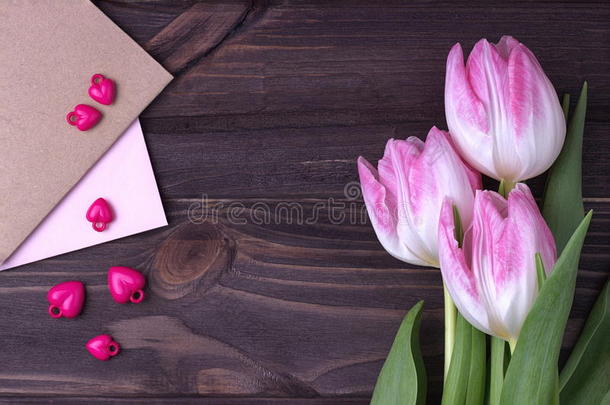 漂亮的粉红色郁金香在木制背景与信封a