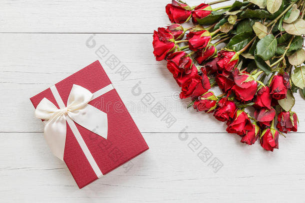 新鲜的红色玫瑰花和<strong>礼品盒</strong>在白色木制甲板上，有空的空间进行<strong>设计</strong>。 为了爱或情人节的概念