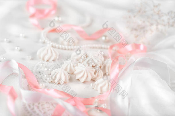 法国奶油饼干的婚礼背景与珍珠，粉红色和白色缎带和花边