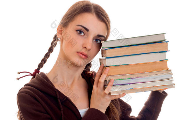 特写照片，年轻迷人的<strong>学生</strong>女孩穿着棕色<strong>运动服</strong>，手里拿着很多书，孤立在白色上