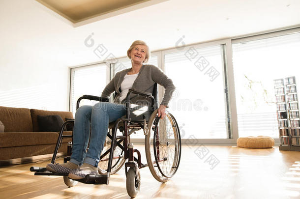 残疾人<strong>老年</strong>妇女坐<strong>轮椅</strong>在家客厅。