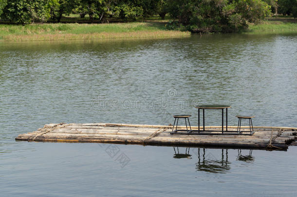 竹筏漂浮在河里，餐桌和椅子上