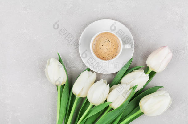 咖啡杯与春天的<strong>花朵</strong>，早上好，在<strong>灰色</strong>的石头桌面上，平躺风格。 母亲或妇女日早餐