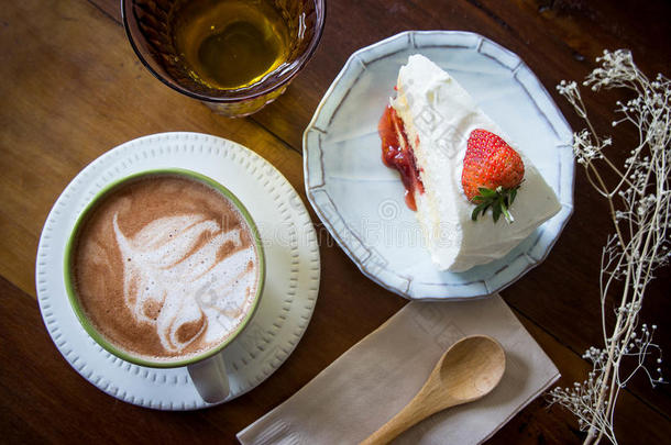 咖啡杯和草莓蛋糕在咖啡店与木背