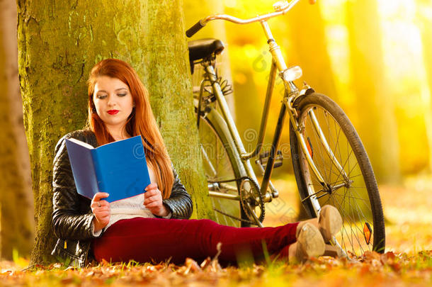 秋天公园里放松的女生看书