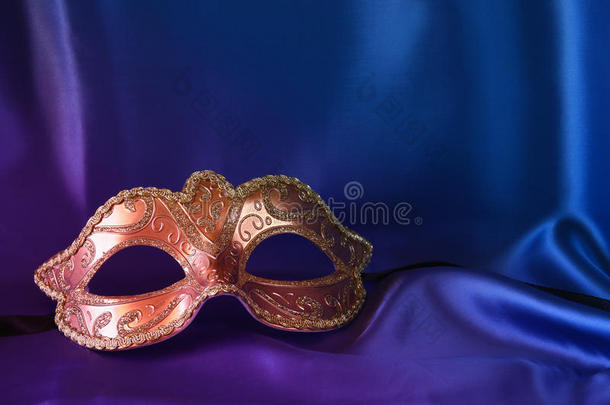 蓝色丝绸背景上的金色威尼斯面具
