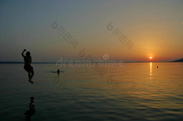 男孩跳入大海，斯塔利格拉德帕克莱尼卡海边日落