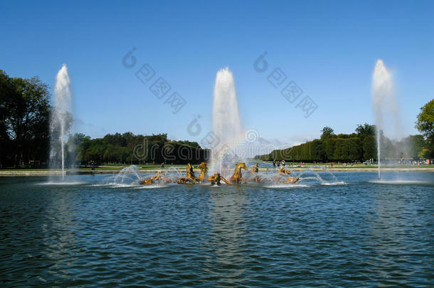 在法国阳光明媚的日子里，美丽的喷泉在宫廷花园里喷水