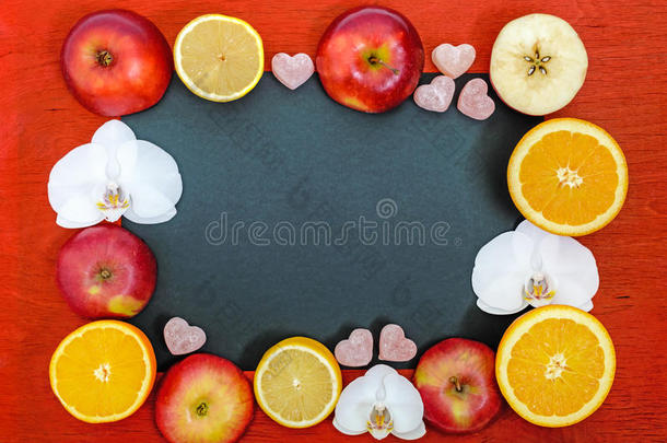 明亮的五彩背景框架与柑橘柠檬，橙色，切割苹果，果冻糖果的形状，一个心