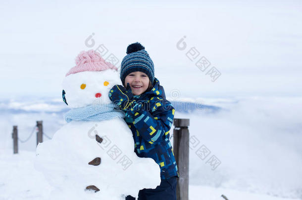 可爱的孩子，堆雪人，在山上玩