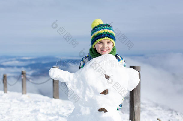 可爱的孩子，<strong>堆雪人</strong>，在山上玩