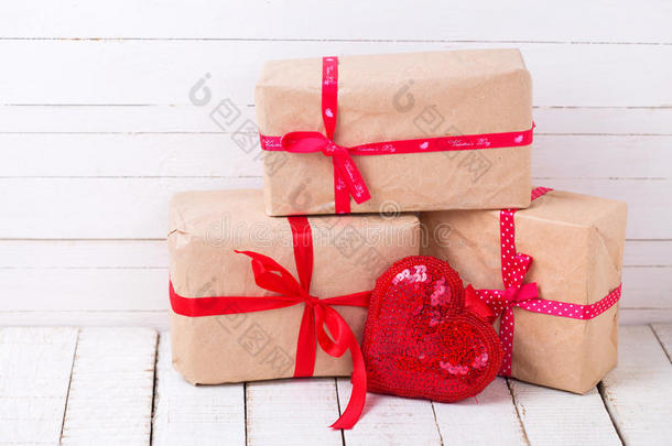白色木制背景上的礼品盒和红色装饰心。