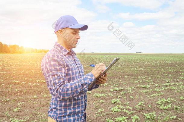 穿着格子衬衫的农民控制着他的<strong>田地</strong>。
