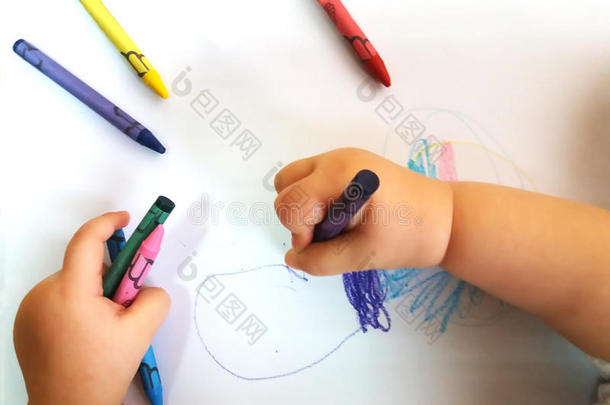 靠近一个小孩子的手，用<strong>彩色铅笔画</strong>一朵花