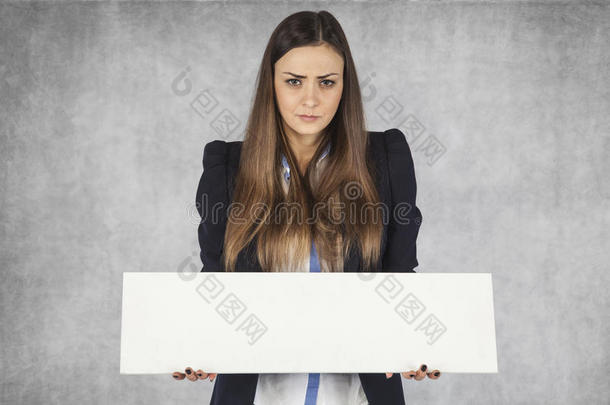 愤怒的商业女人为你的广告占有一席之地，站在灰色的背景上